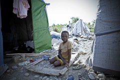 Haiti, girl between tents and stones